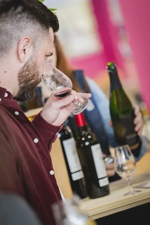 Un homme sent son verre de vin