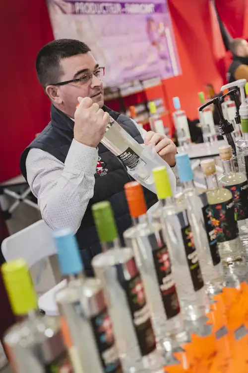 Exposant avec bouteille en main