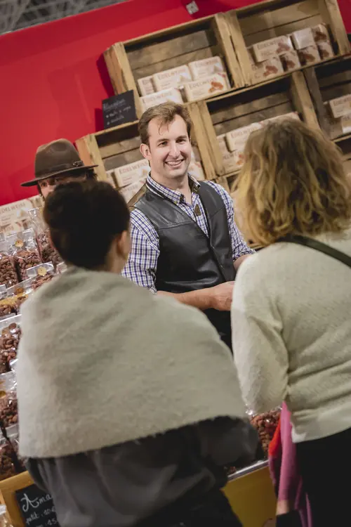 Exposant souriant à deux visiteuses