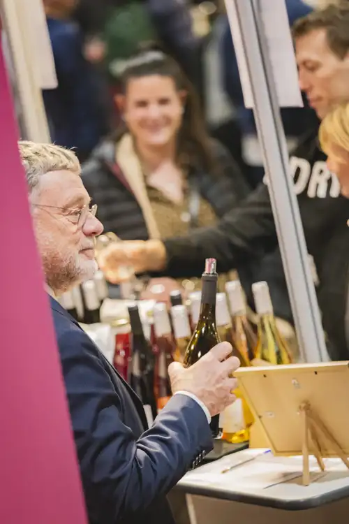 Exposant avec bouteille en main
