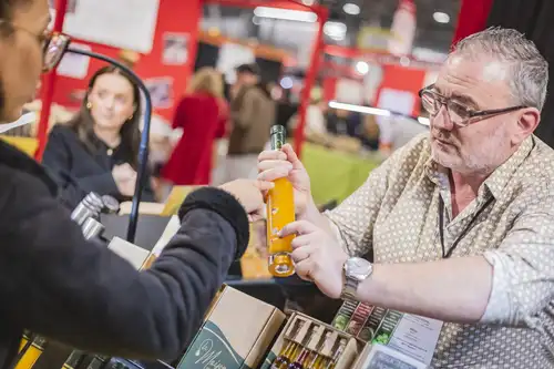 Un homme qui tient une bouteille dans les mains, montre l'appellation