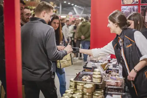 Une exposante tend à des visiteurs de la nourriture